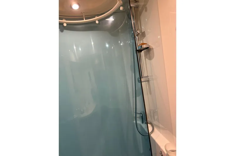  Yacht Photos Pics Shower area in 2008 Beneteau 49 yacht with modern fixtures and blue curtain.