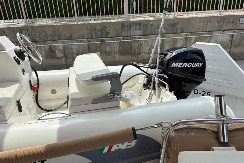  Yacht Photos Pics Small boat with Mercury outboard motor, docked near a Beneteau 49, 2008 model.