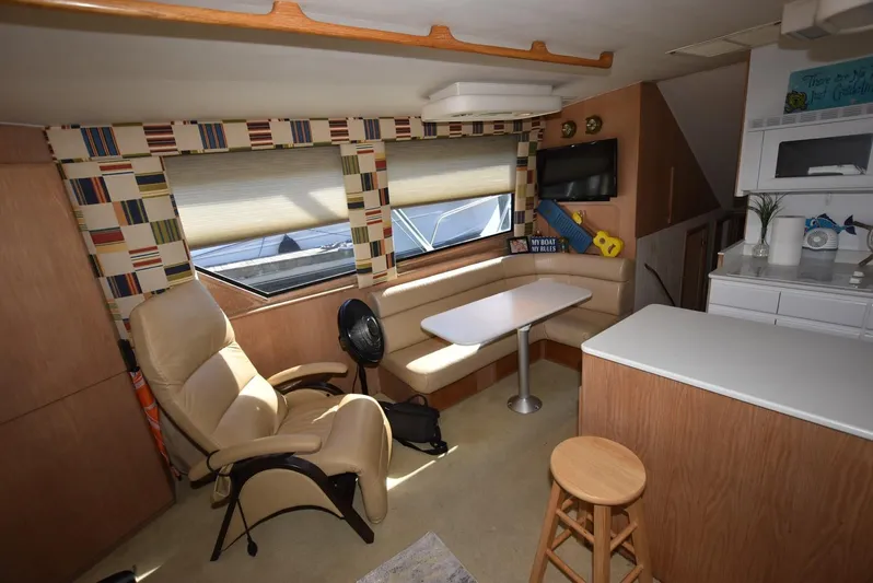 Crazy Train Yacht Photos Pics Interior of 1996 Hatteras 50 Convertible yacht with seating, table, and kitchenette.