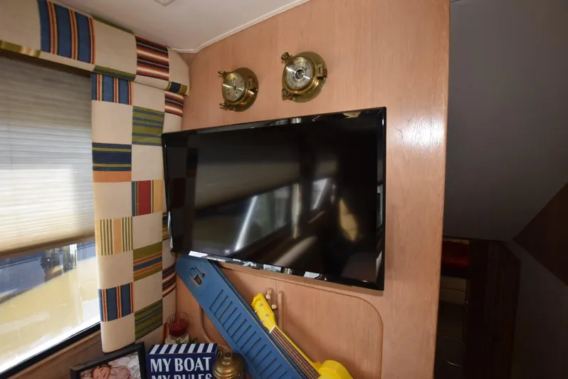 Crazy Train Yacht Photos Pics Interior of 1996 Hatteras 50 Convertible with TV, nautical decor, and striped curtains.