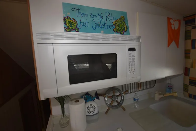 Crazy Train Yacht Photos Pics Kitchen area of a 1996 Hatteras 50 Convertible with microwave and decor.