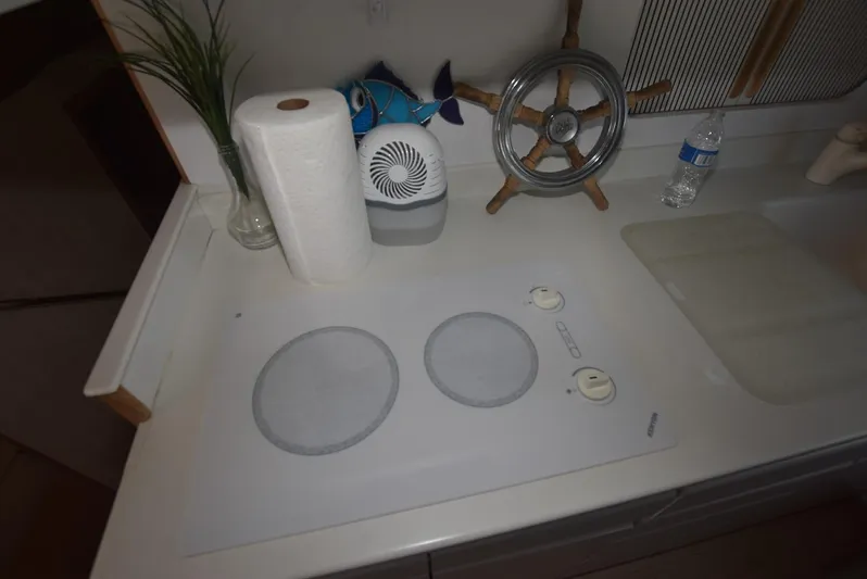 Crazy Train Yacht Photos Pics 1996 Hatteras 50 Convertible kitchen with stove, paper towels, and nautical decor.