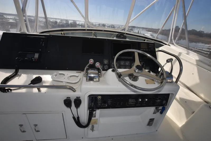 Crazy Train Yacht Photos Pics 1996 Hatteras 50 Convertible helm with steering wheel and control panel.