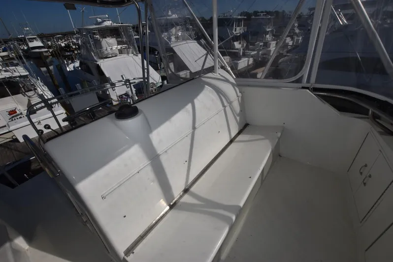 Crazy Train Yacht Photos Pics 1996 Hatteras 50 Convertible boat interior with white seating and marina view.
