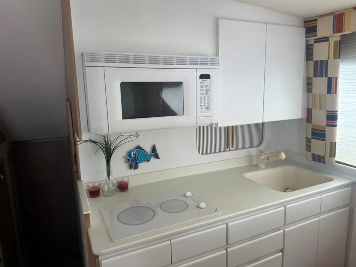 Crazy Train Yacht Photos Pics Kitchen area of 1996 Hatteras 50 Convertible yacht with microwave and stove.