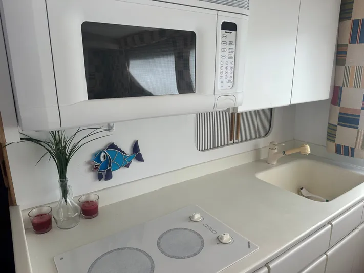 Crazy Train Yacht Photos Pics Kitchen area of a 1996 Hatteras 50 Convertible yacht with microwave and cooktop.