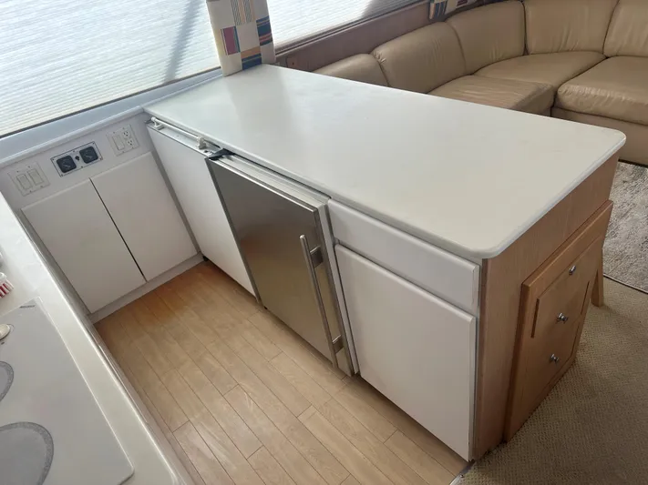 Crazy Train Yacht Photos Pics Interior of 1996 Hatteras 50 Convertible yacht with modern kitchen and seating area.