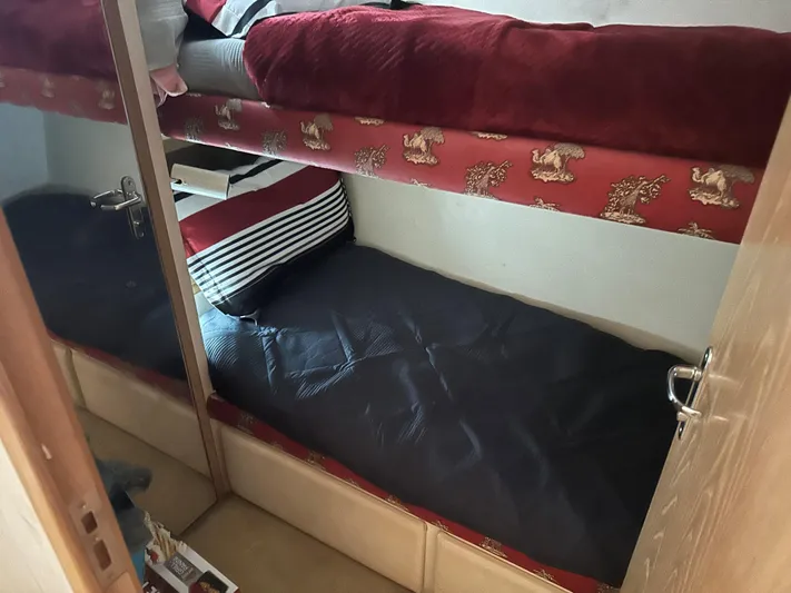 Crazy Train Yacht Photos Pics Bunk beds in a 1996 Hatteras 50 Convertible yacht cabin, featuring red and black bedding.