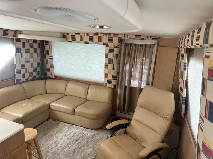 Crazy Train Yacht Photos Pics Interior of 1996 Hatteras 50 Convertible yacht with beige seating and patterned curtains.
