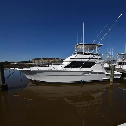 Crazy Train Yacht Photos Pics 1996 Hatteras 50 Convertible yacht docked in marina, side view.