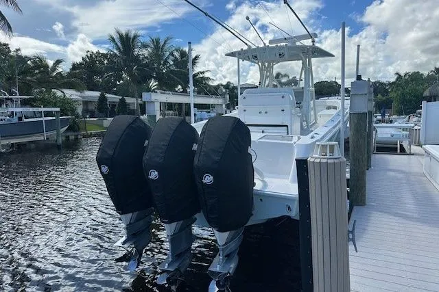 Reel Craft Yacht Photos Pics 2024 SeaVee 340Z boat docked, featuring triple outboard engines, under a partly cloudy sky.