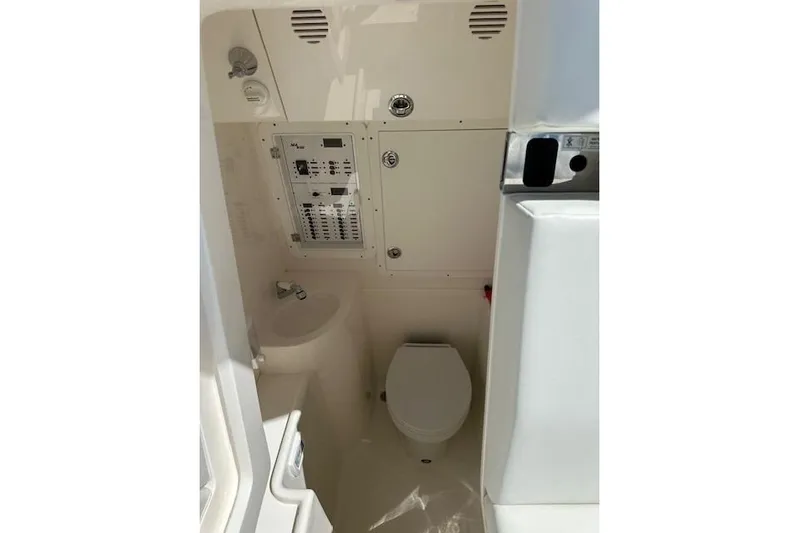 Reel Craft Yacht Photos Pics 2024 SeaVee 340Z boat interior with compact bathroom and control panel.