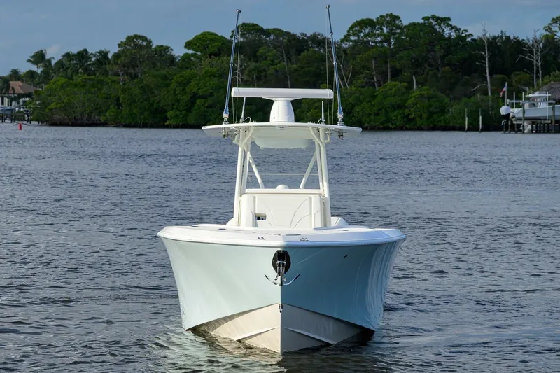Reel Craft Yacht Photos Pics 2024 SeaVee 340Z boat on calm water, surrounded by lush greenery.