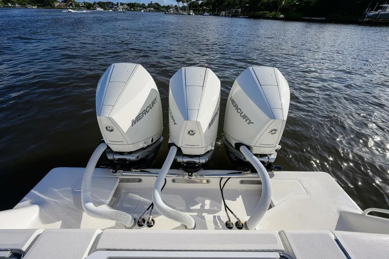 Reel Craft Yacht Photos Pics Triple Mercury outboard engines on a 2024 SeaVee 340Z boat, docked on a calm river.