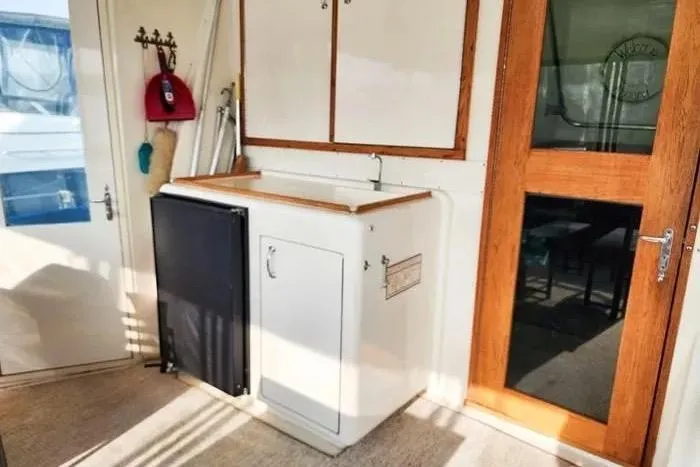  Yacht Photos Pics 1988 Hatteras 43 Motor Yacht interior with compact kitchenette and wooden door.