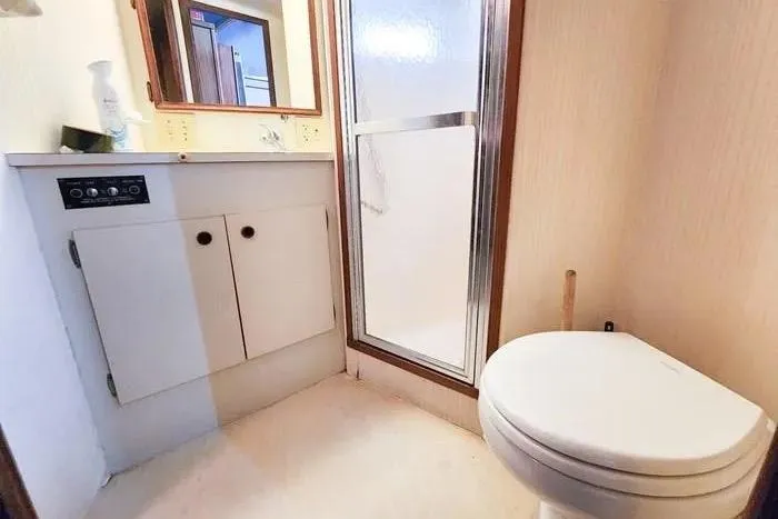  Yacht Photos Pics 1988 Hatteras 43 Motor Yacht bathroom with shower, toilet, and vanity cabinet.