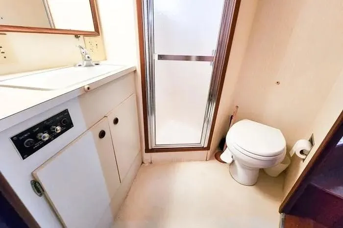  Yacht Photos Pics Bathroom interior of 1988 Hatteras 43 Motor Yacht with shower, sink, and toilet.