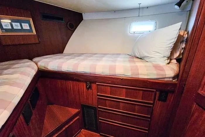  Yacht Photos Pics 1988 Hatteras 43 Motor Yacht cabin with wooden interior and cozy bedding.