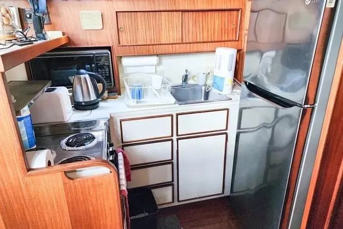  Yacht Photos Pics Compact kitchen in 1988 Hatteras 43 Motor Yacht with appliances and wooden cabinetry.