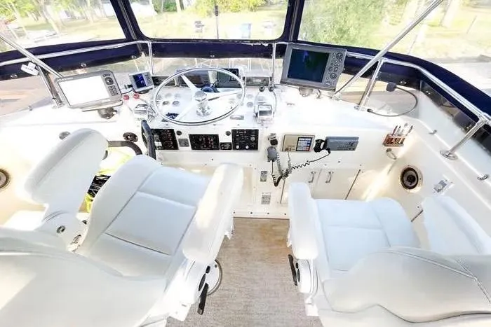  Yacht Photos Pics 1988 Hatteras 43 Motor Yacht helm with dual white captain chairs and navigation equipment.