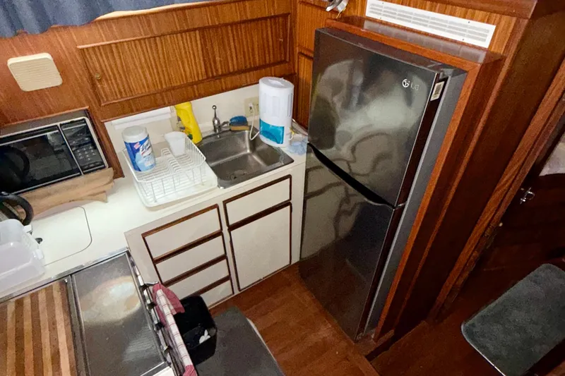  Yacht Photos Pics 1988 Hatteras 43 Motor Yacht kitchen with stainless steel fridge and wooden cabinetry.