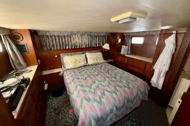  Yacht Photos Pics 1988 Hatteras 43 Motor Yacht bedroom with patterned bedding and wood paneling.