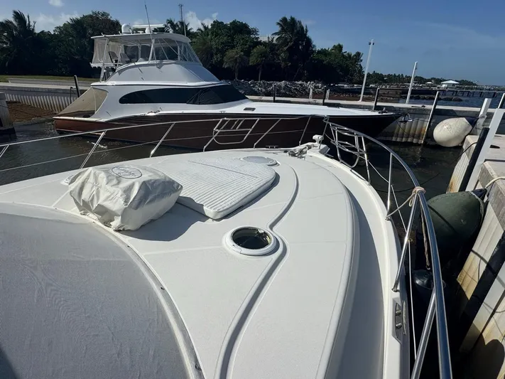  Yacht Photos Pics 2009 Silverton 45 Convertible yacht docked near another boat, sunny day, calm waters.