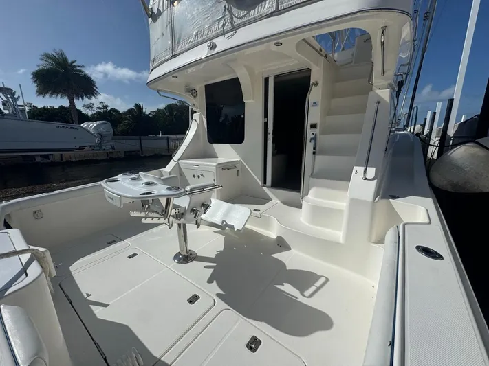  Yacht Photos Pics 2009 Silverton 45 Convertible yacht deck with fishing chair and sunny marina backdrop.