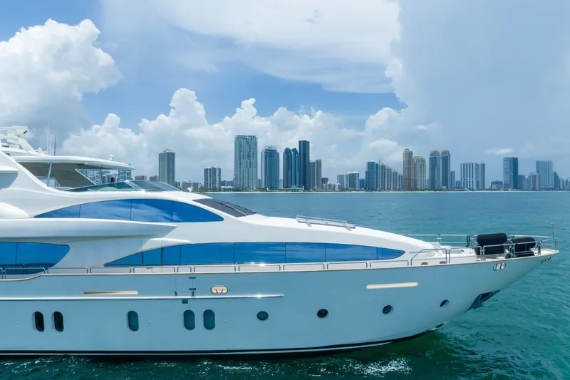  Yacht Photos Pics Luxurious 2012 Azimut yacht cruising near a city skyline under a cloudy sky.