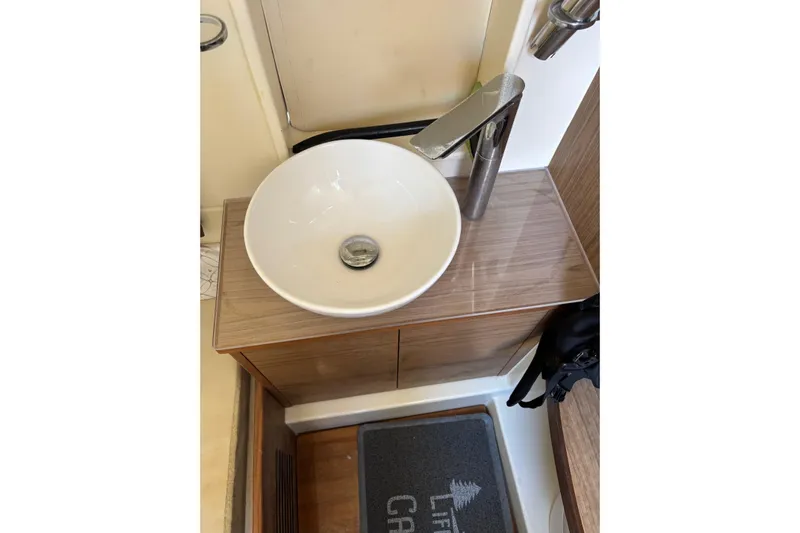  Yacht Photos Pics Modern bathroom sink in 2018 Chris-Craft 350 Catalina yacht, featuring sleek faucet and wooden cabinetry.