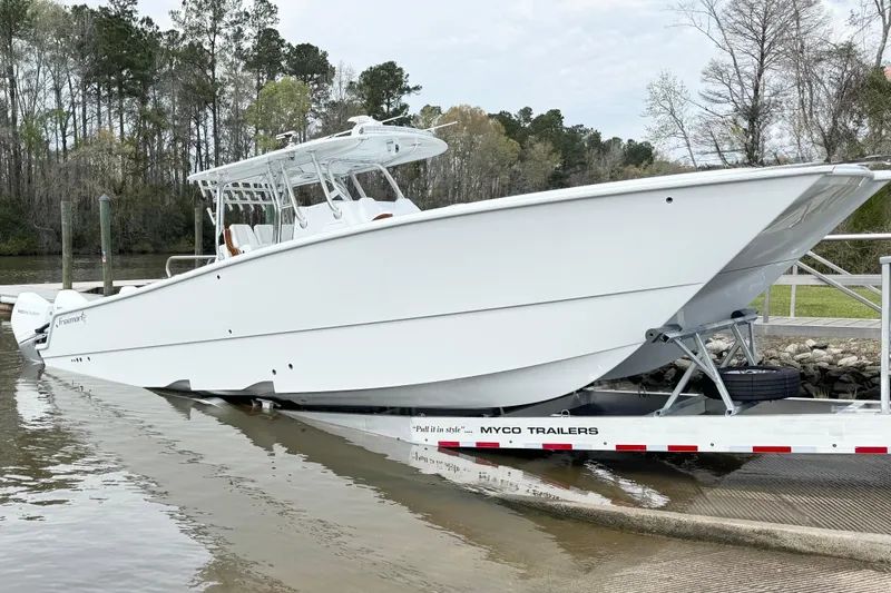  Yacht Photos Pics 2024 Freeman 38 boat on trailer at a boat ramp, surrounded by trees.