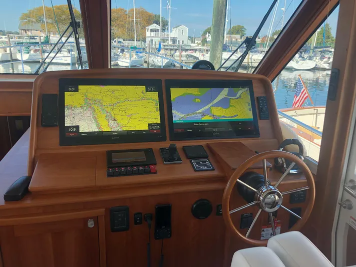 Apricity Yacht Photos Pics 2021 Sabre 58 Salon Express helm with dual navigation screens and wooden steering wheel.