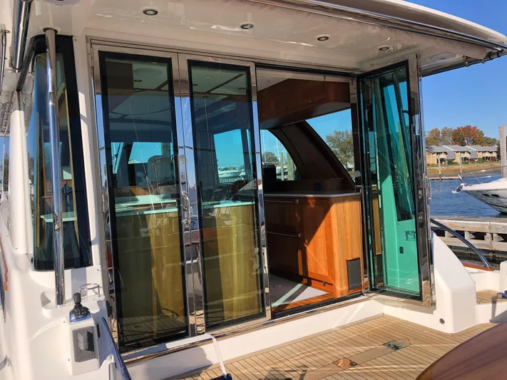Apricity Yacht Photos Pics 2021 Sabre 58 Salon Express yacht with open glass doors, showcasing luxurious interior.