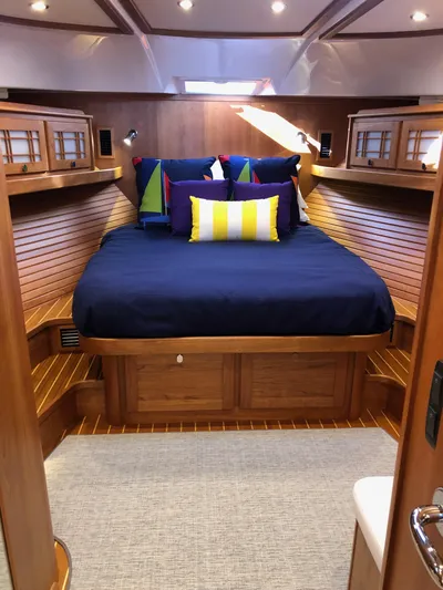 Apricity Yacht Photos Pics Luxurious 2021 Sabre 58 Salon Express cabin with cozy bedding and elegant wood finish.