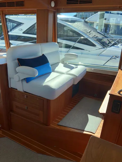 Apricity Yacht Photos Pics 2021 Sabre 58 Salon Express interior with white seating and blue accent pillow.