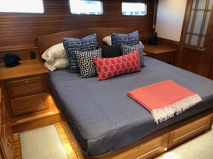 Apricity Yacht Photos Pics Luxurious 2021 Sabre 58 Salon Express bedroom with stylish bedding and wood paneling.