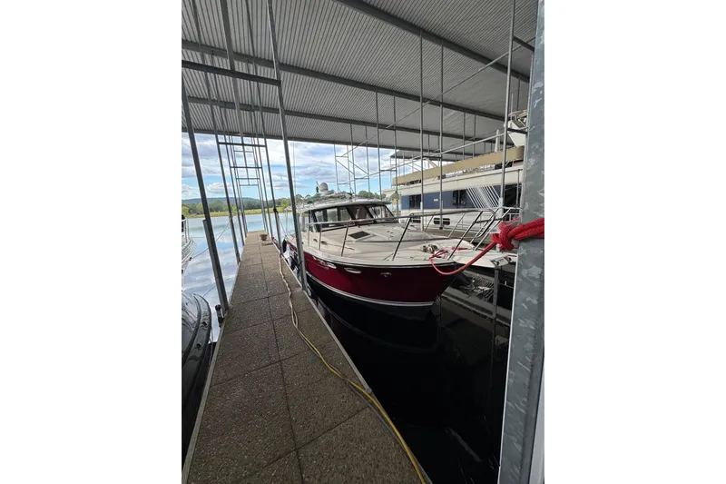 Fluidmotion Yacht Photos Pics 2020 Cutwater C-30S boat docked under a covered marina with scenic background.