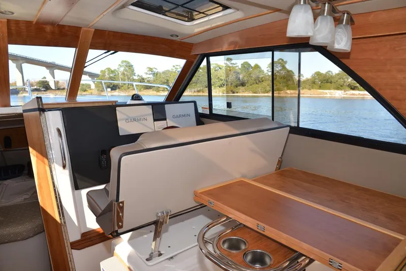 Fluidmotion Yacht Photos Pics 2020 Cutwater C-30S interior with Garmin navigation, wooden table, and scenic water view.