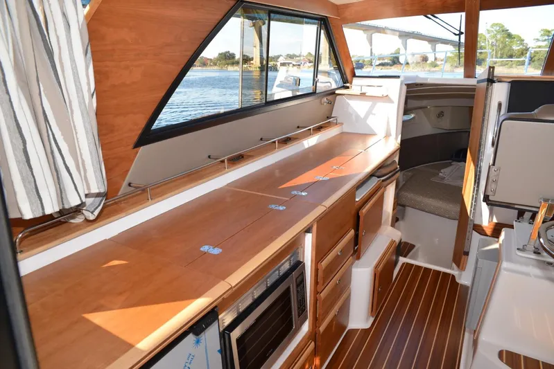 Fluidmotion Yacht Photos Pics 2020 Cutwater C-30S interior with wood finish, kitchenette, and seating area.