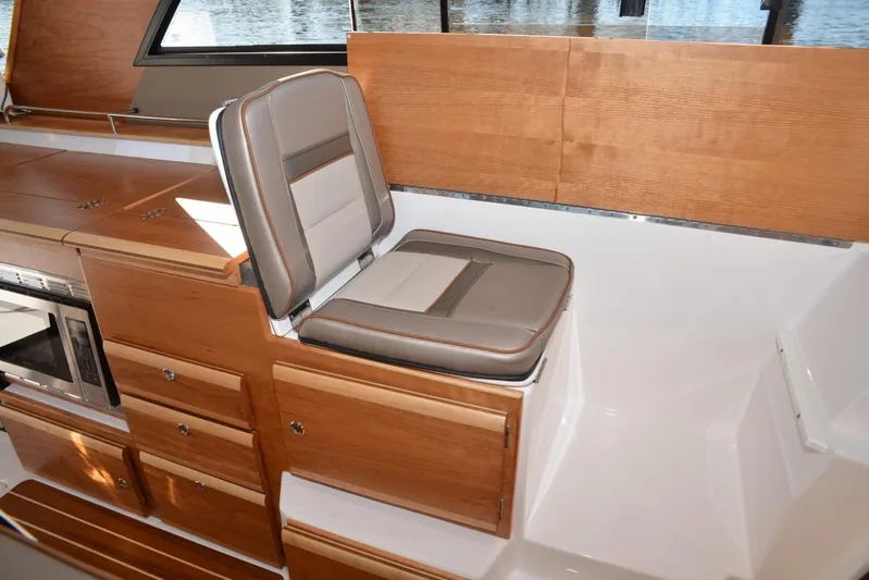 Fluidmotion Yacht Photos Pics 2020 Cutwater C-30S interior with wood cabinetry and cushioned seating.