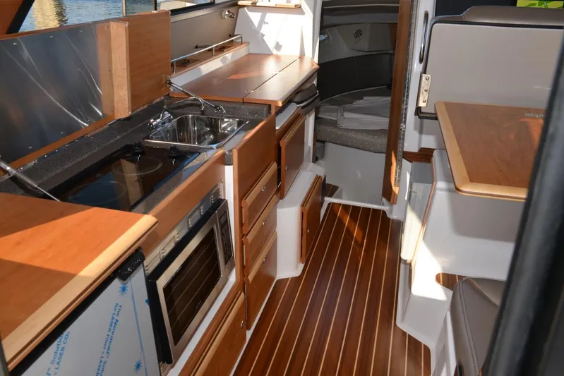 Fluidmotion Yacht Photos Pics 2020 Cutwater C-30S interior with wood flooring, kitchenette, and cozy seating area.