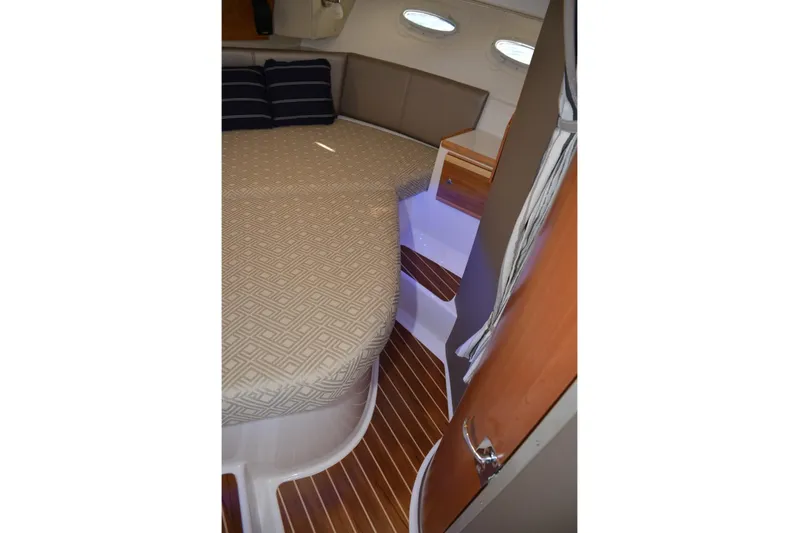 Fluidmotion Yacht Photos Pics 2020 Cutwater C-30S cabin interior with bed, wooden flooring, and ambient lighting.