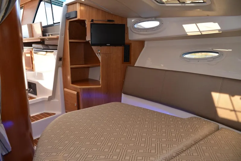 Fluidmotion Yacht Photos Pics 2020 Cutwater C-30S interior cabin with bed, shelves, and porthole windows.