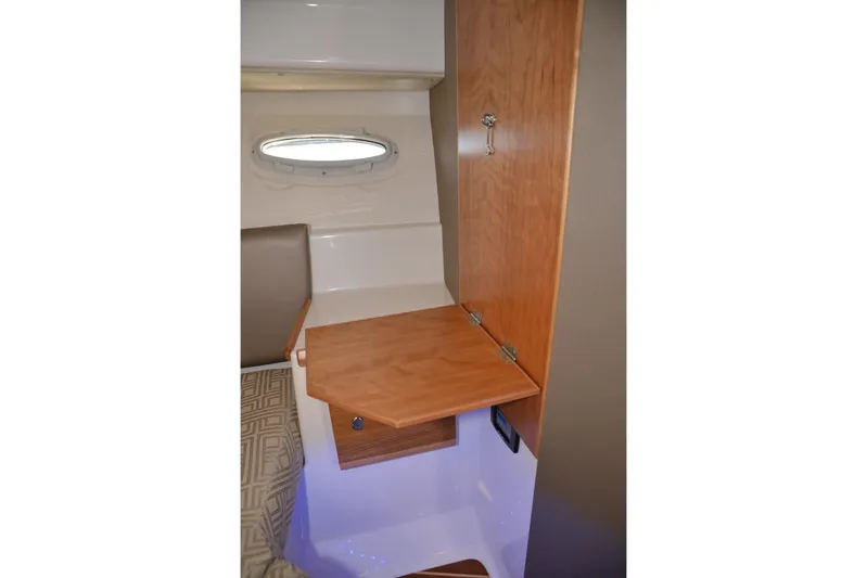 Fluidmotion Yacht Photos Pics 2020 Cutwater C-30S interior with wooden fold-out table and porthole window.