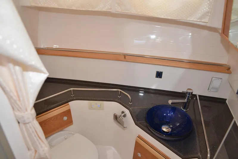 Fluidmotion Yacht Photos Pics 2020 Cutwater C-30S bathroom with modern sink, toilet, and wood accents.