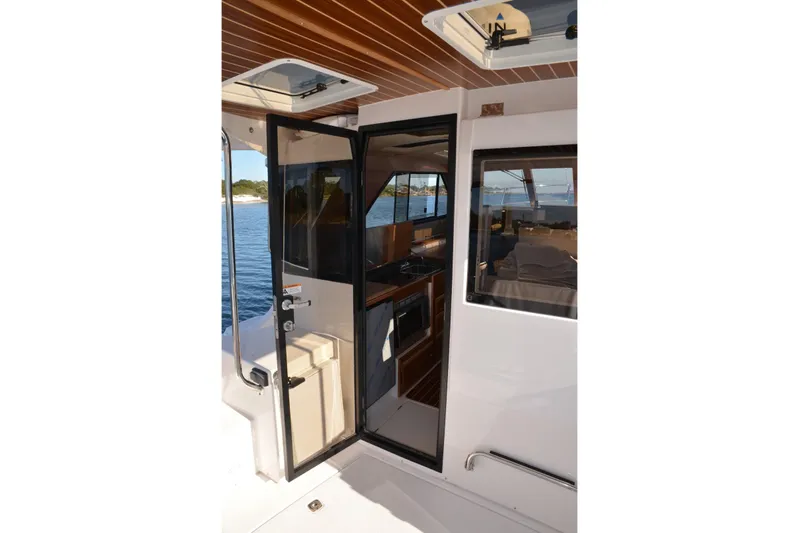Fluidmotion Yacht Photos Pics 2020 Cutwater C-30S boat interior with open door, showcasing cabin and water view.