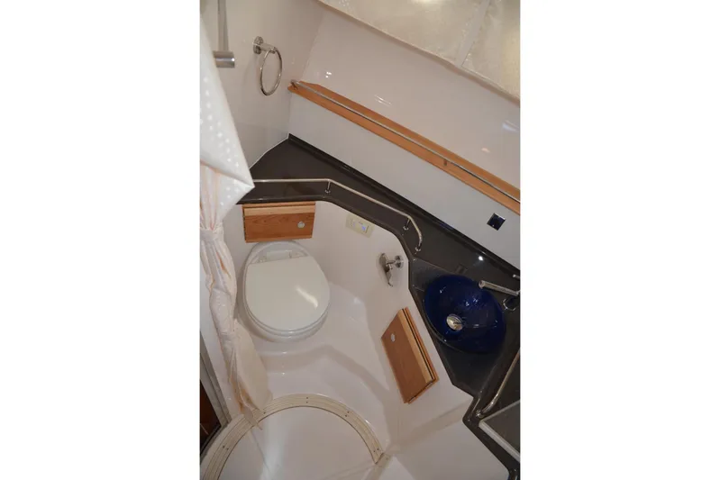 Fluidmotion Yacht Photos Pics 2020 Cutwater C-30S boat bathroom with toilet, blue sink, and wooden accents.