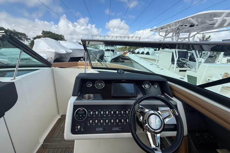  Yacht Photos Pics 2015 Sea Ray SLX 350 helm with modern controls and steering wheel, docked under blue sky.