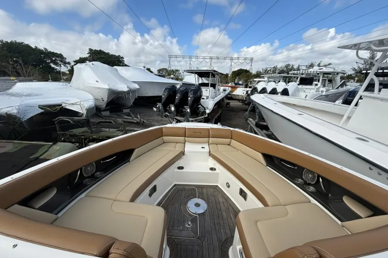  Yacht Photos Pics 2015 Sea Ray SLX 350 boat interior with tan seating, docked among other boats.