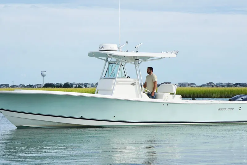  Yacht Photos Pics 2006 Regulator 32 Forward Seating boat on calm water with a person standing.